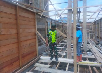 Wujud kepedulian babinsa Koramil 02 / Bebesen bantu warga pasang papan dinding rumah