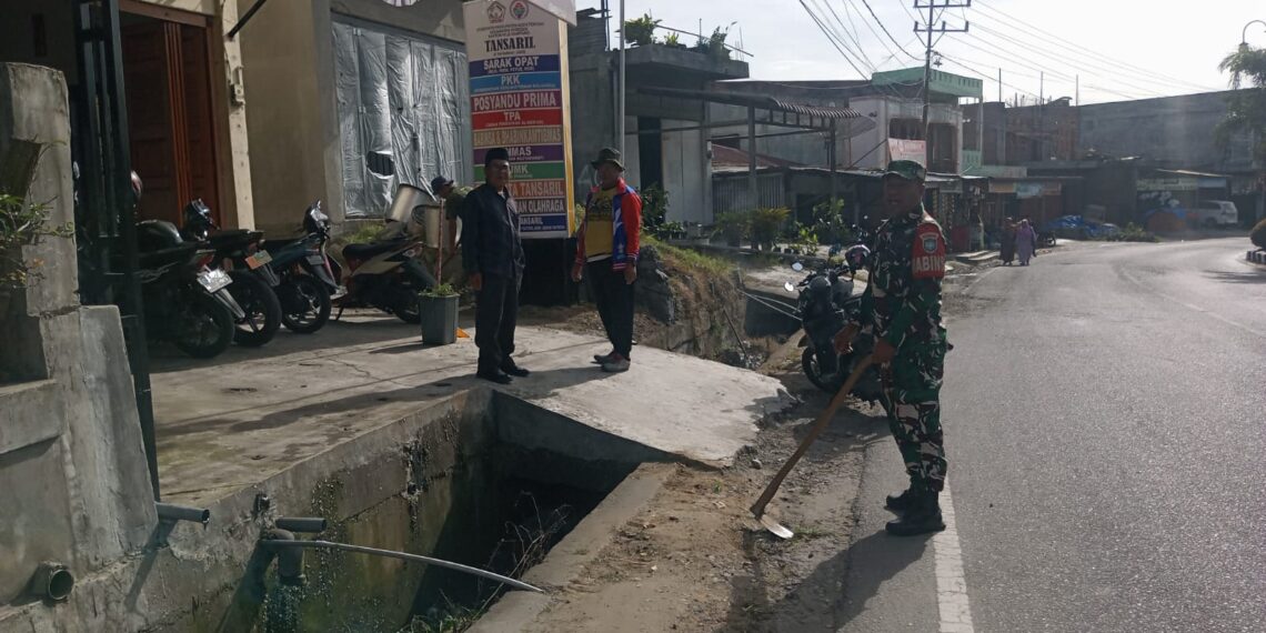 Babinsa koramil 02/Bebesen bersama perangkat desa gotong royong bersihkan lingkungan kantor desa.