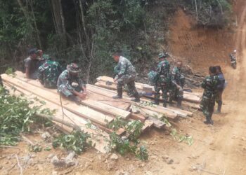 anggota Satgas TMMD 0106 bergotong royong membuat jembatan penghubung antar Dusun