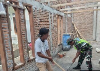 Manunggal dengan rakyat babinsa koramil 02/bebesen bantu aduk pasir dan semen untuk pembangunan rumah binaan